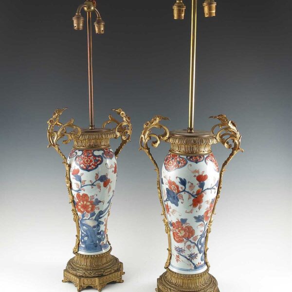 A pair of Imari and ormolu mounted table lamps, decorated in iron reds and blue leaves
